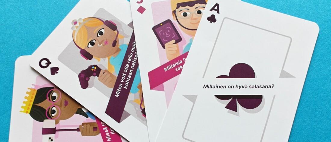 Neljä pelikorttia, joissa on värikkäitä kuvituksia ja tekstiä. Kortit on aseteltu hieman päällekkäin sinisellä pinnalla.