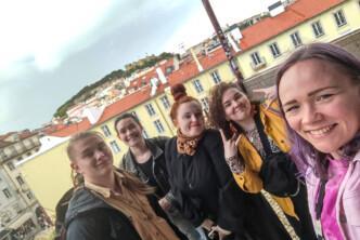 Viisi hankkeen osallistujaa yhteiskuvassa Lissabonissa. Taustalla näkyy vaaleita rakennuksia punaisine kattotiilineen sekä kaupungin mäkinen maisema.