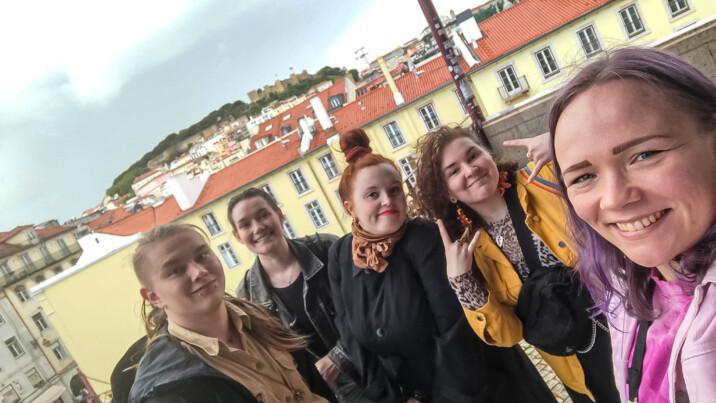 Viisi hankkeen osallistujaa yhteiskuvassa Lissabonissa. Taustalla näkyy vaaleita rakennuksia punaisine kattotiilineen sekä kaupungin mäkinen maisema.